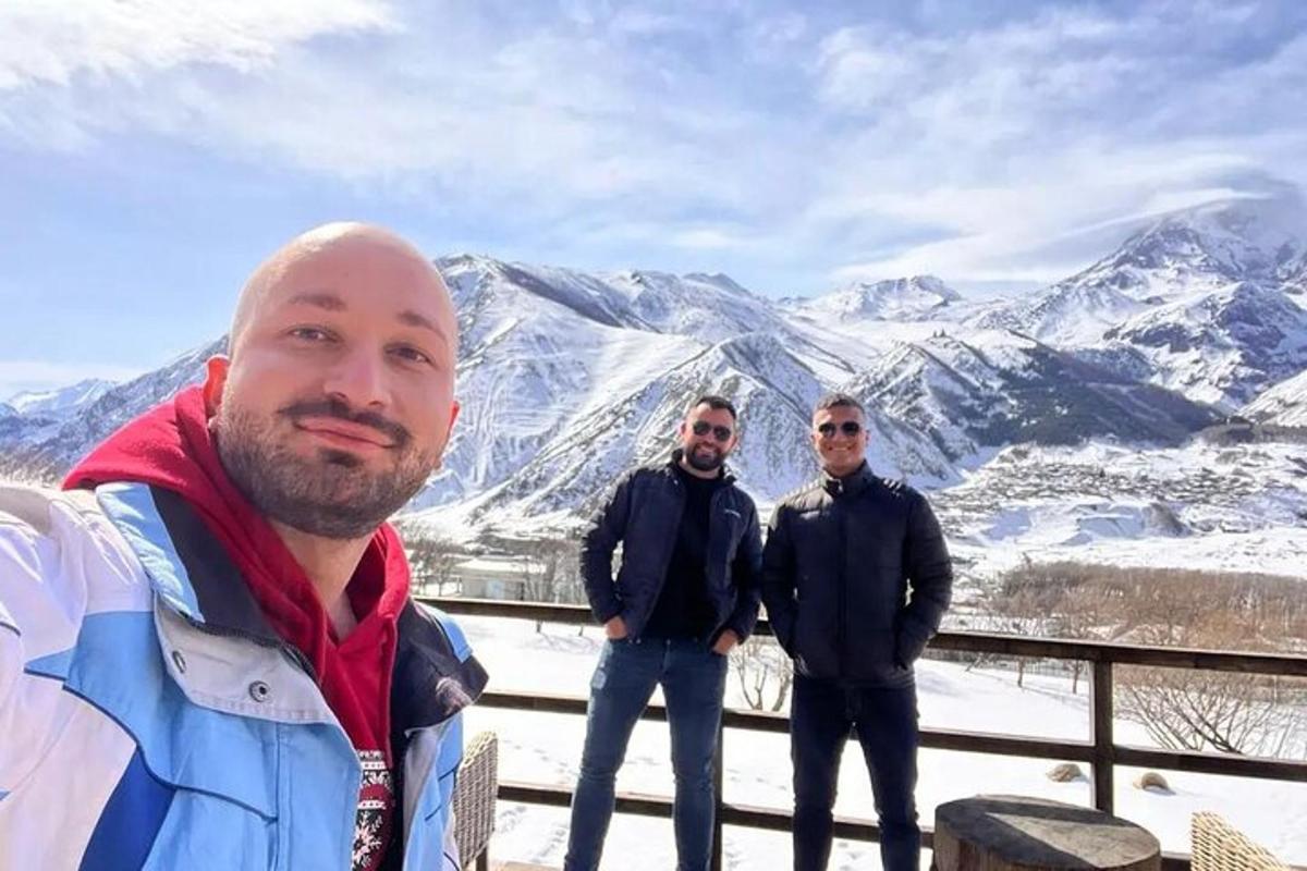 μια ομάδα τριών ανδρών που στέκονται μπροστά σε ένα βουνό