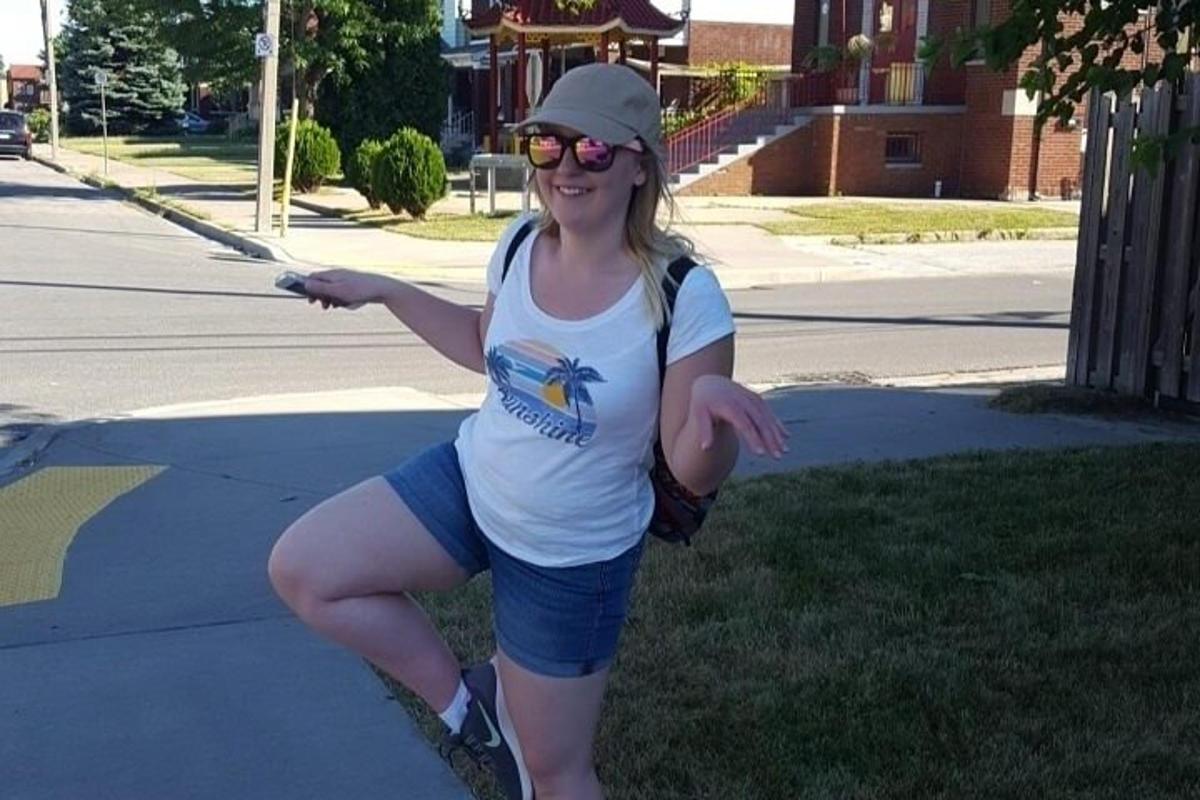 a woman standing on a skateboard on a sidewalk