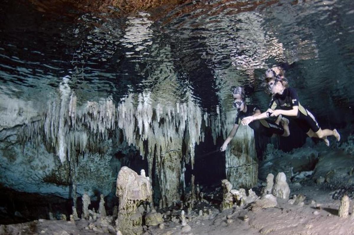 un dipinto di due persone in una grotta con formazioni di ghiaccio