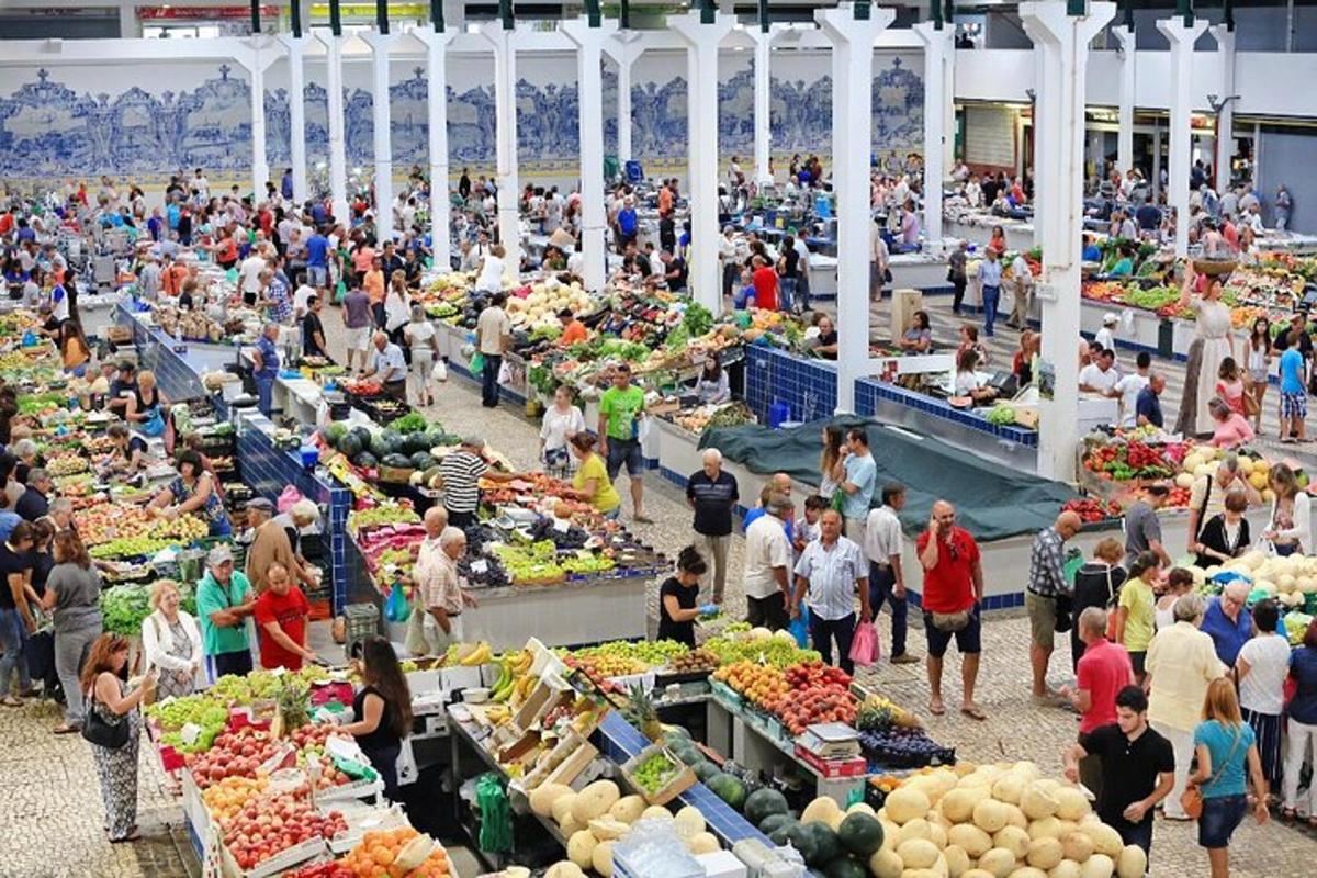 a crowd of people walking around a farmers market