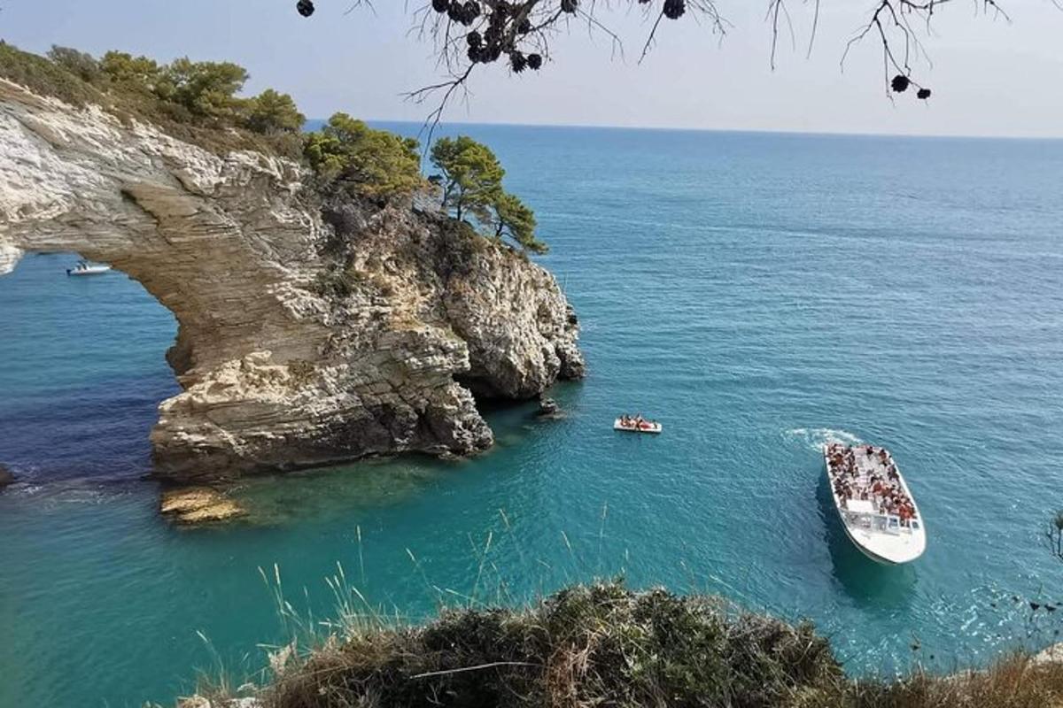 a group of boats in the water near a cliff