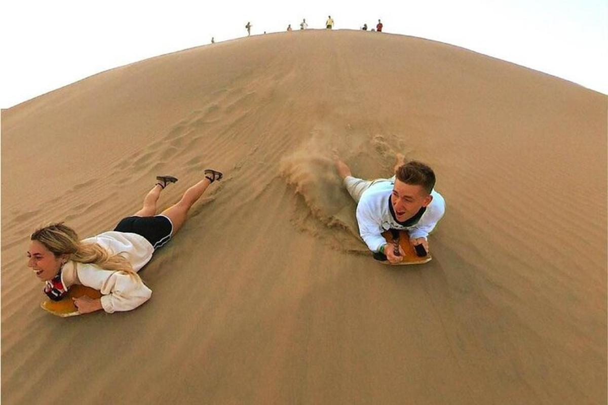 ein Mann und eine Frau spielen auf Skateboards im Sand