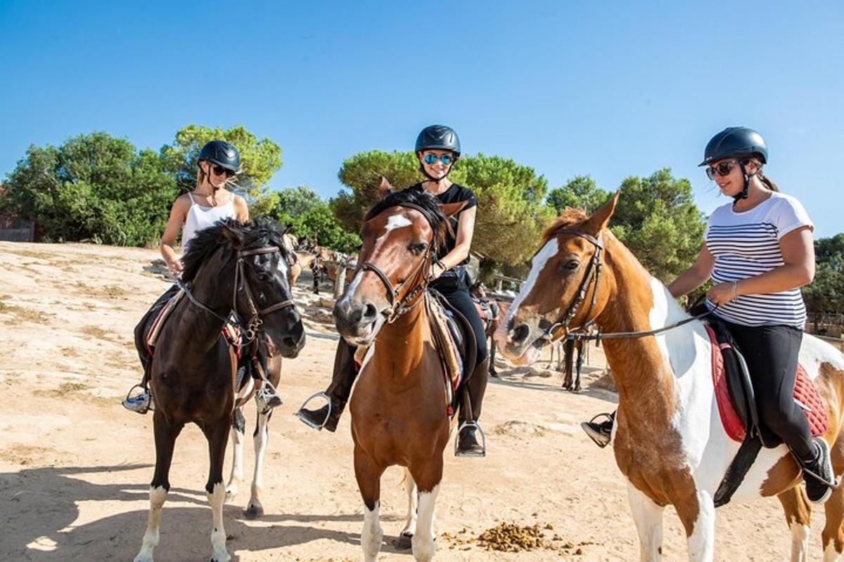 Tres mujeres montando a caballo por un camino de tierra