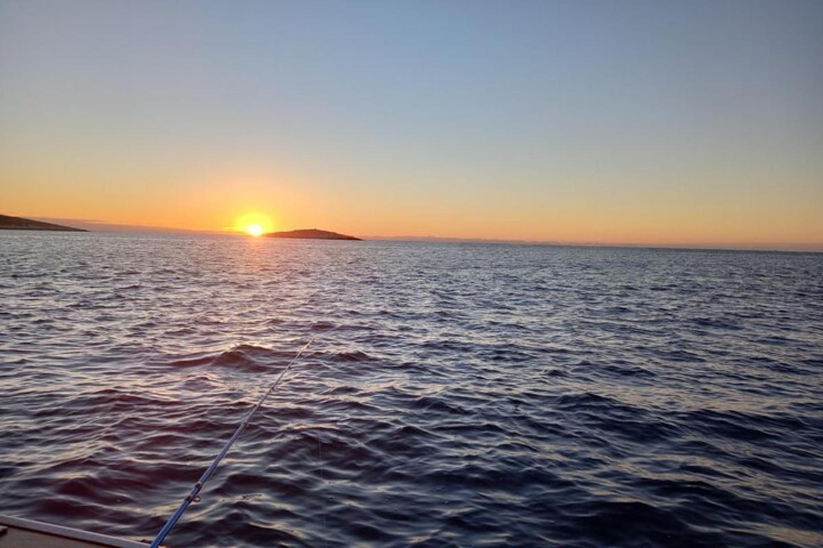 isang bangka sa tubig na may background sa paglubog ng araw