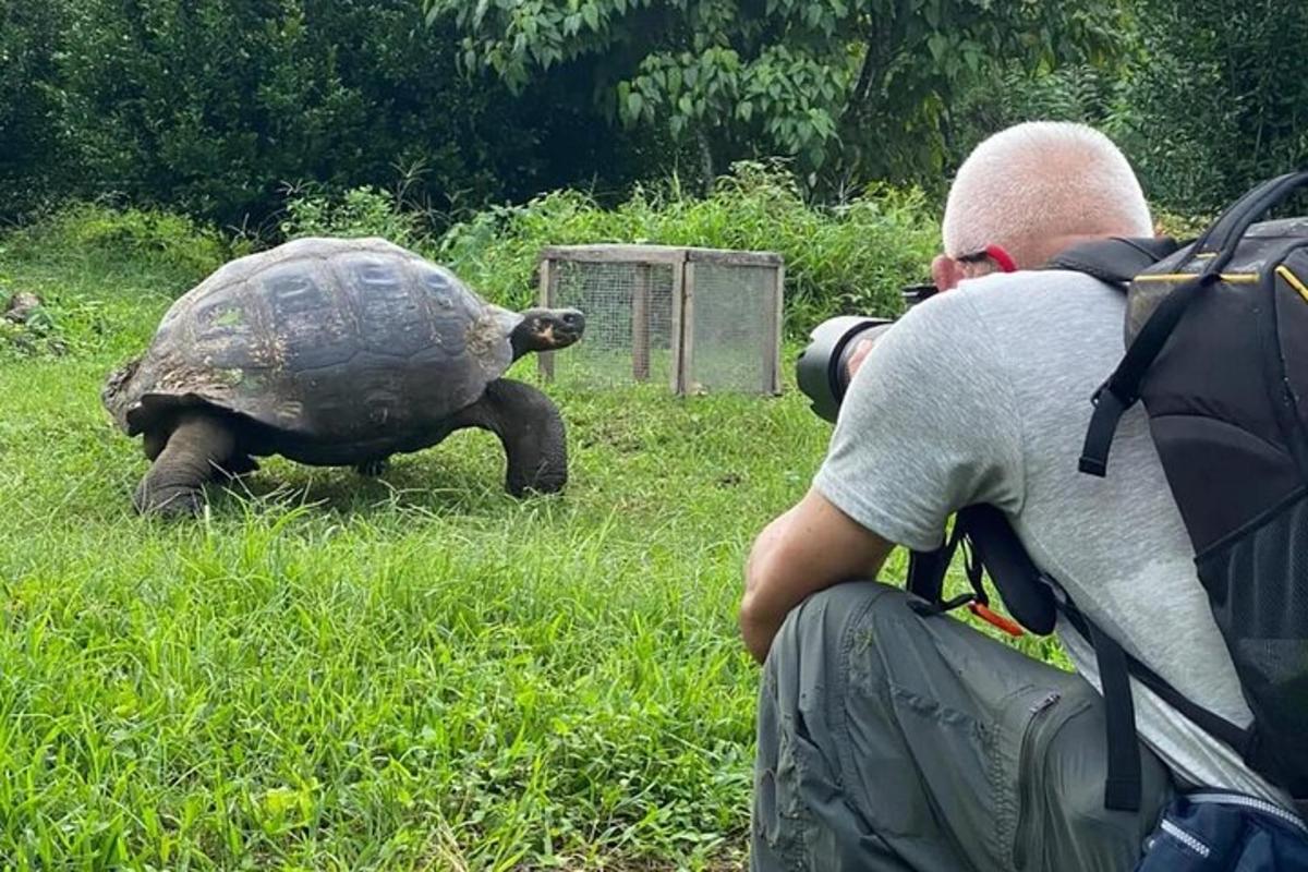 a man taking a picture of a turtle with a camera
