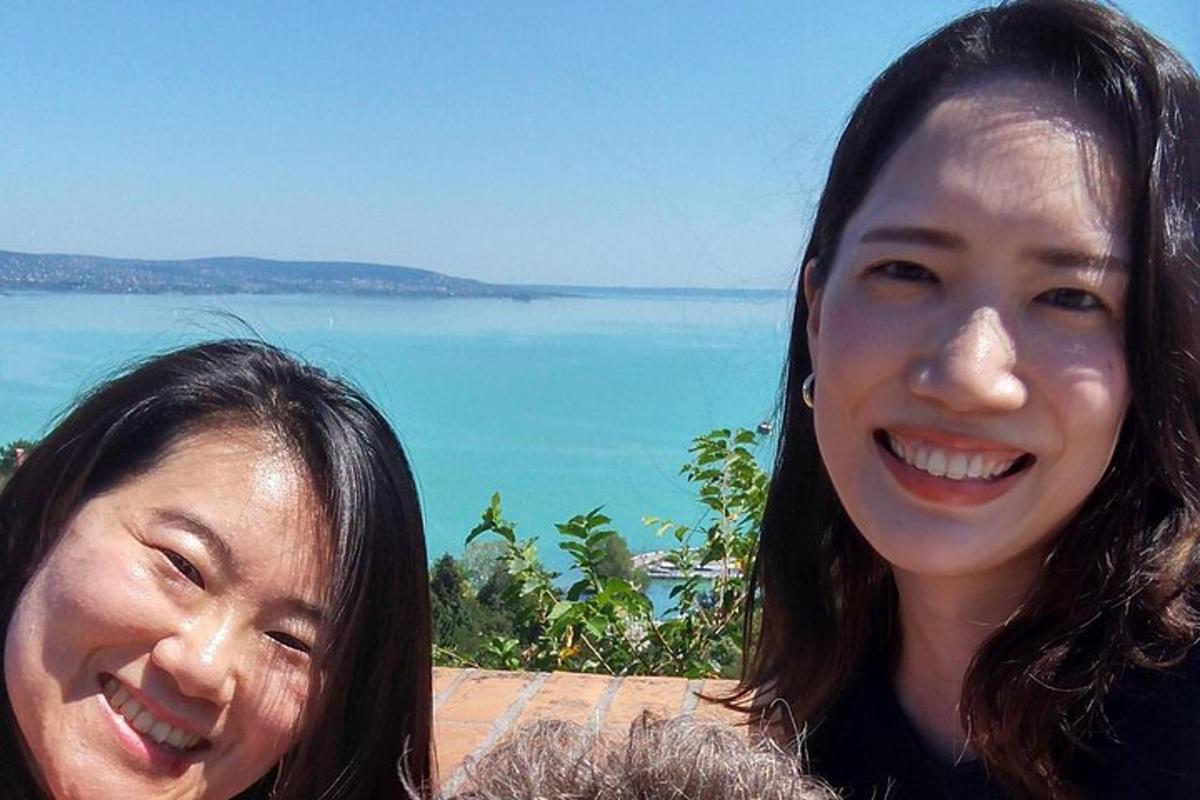 two women standing next to each other in front of the ocean