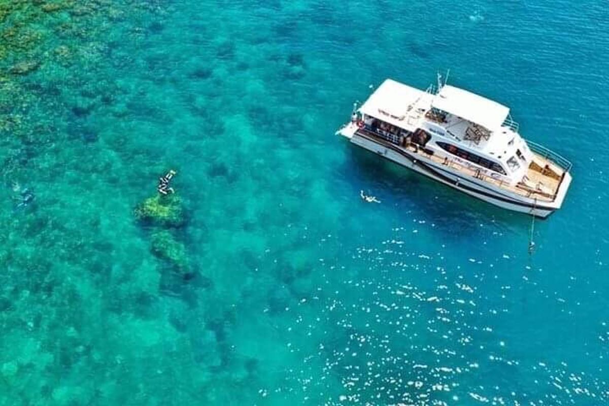 um barco flutuando na água próximo a um recife