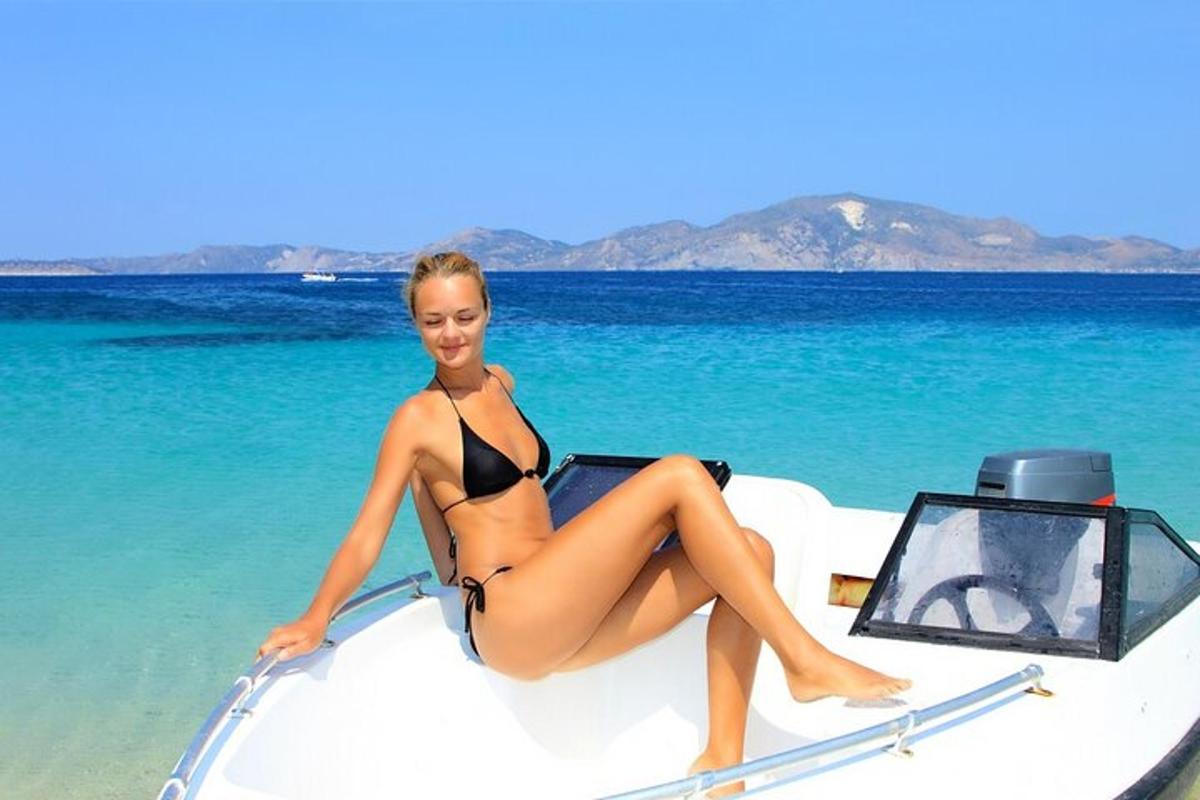 žena v bikinách sedící na přední straně lodi