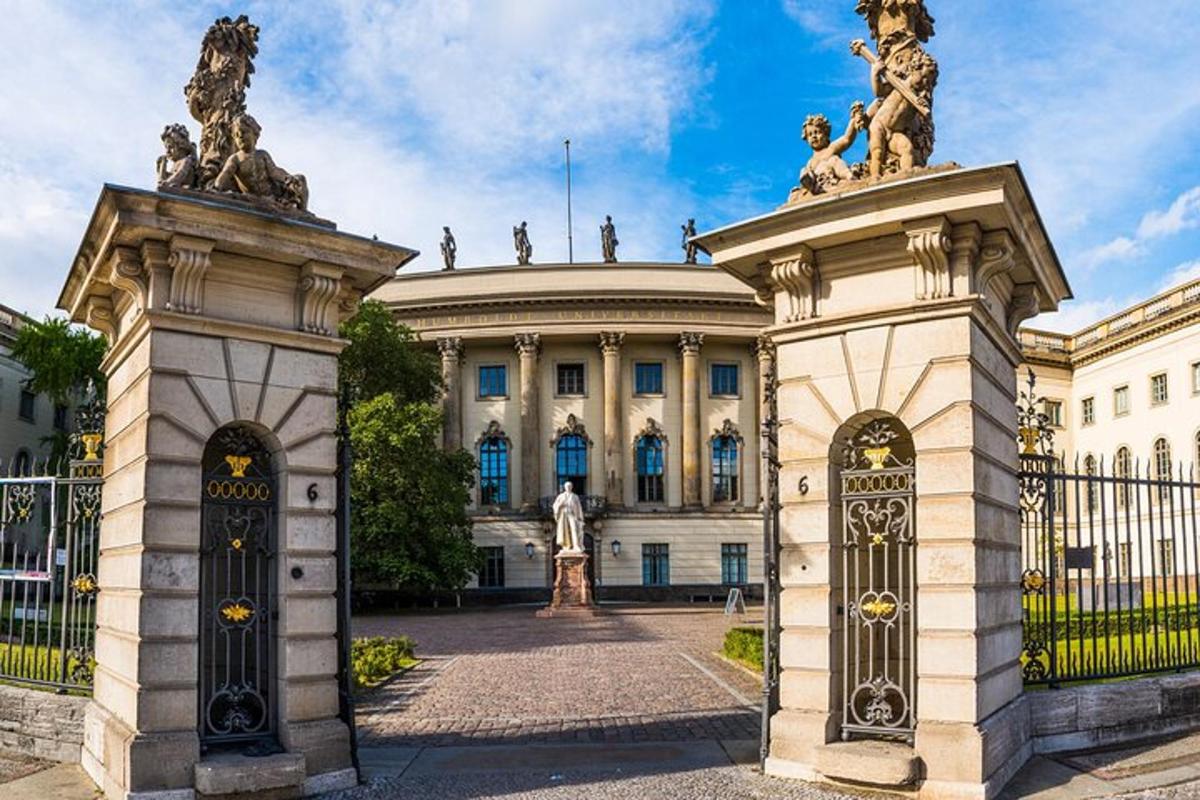 a gate in front of a building with statues