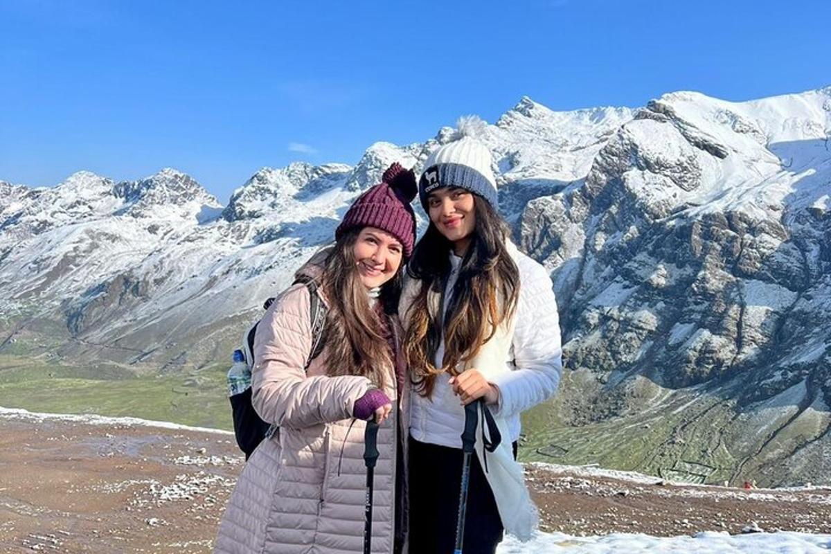 dos mujeres de pie en la cima de una montaña