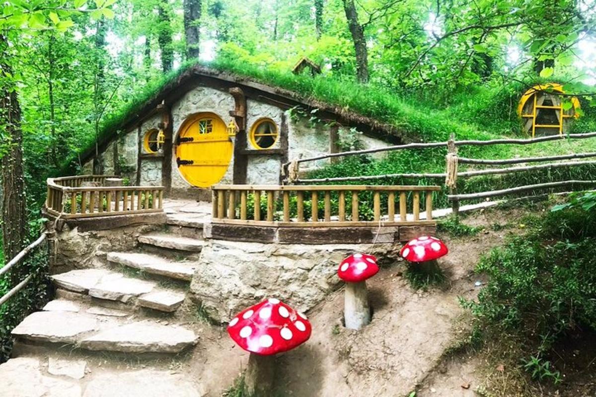 Un cuadro de una casa en el bosque con setas.