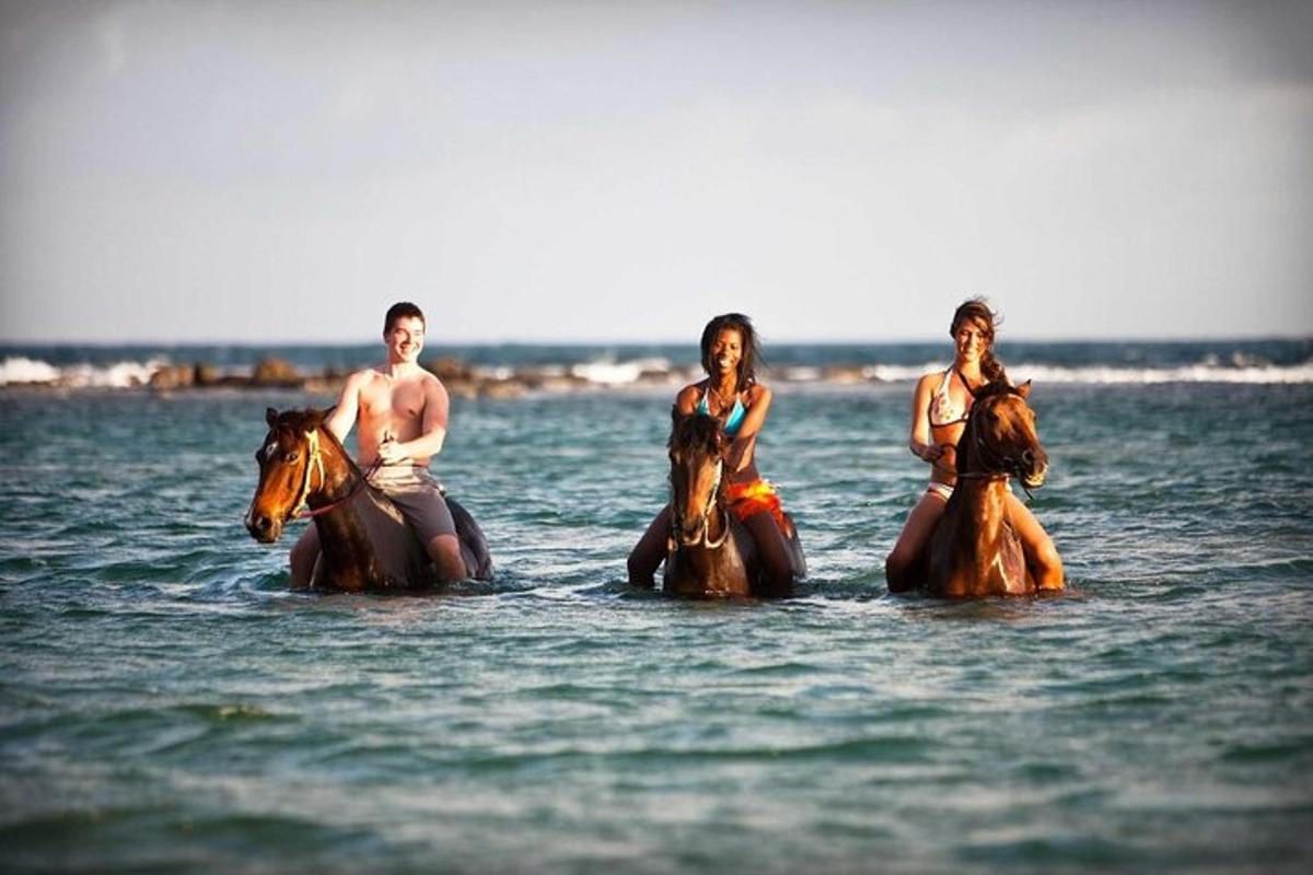 Un grupo de personas montando a caballo en el agua.