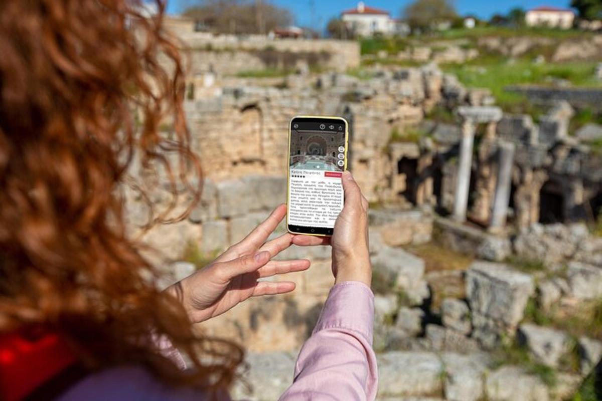 una donna che tiene in mano un telefono cellulare davanti a dei manufatti