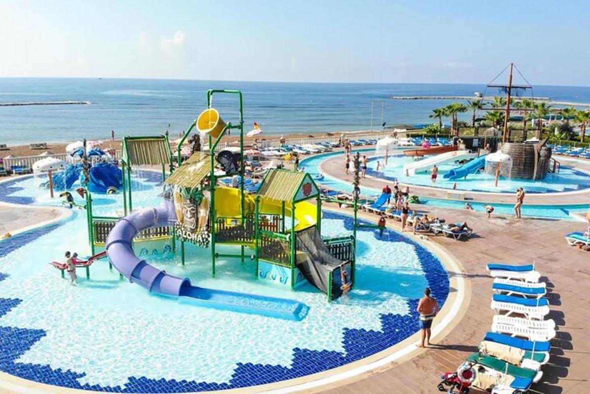 un parco acquatico con scivoli e gente in spiaggia