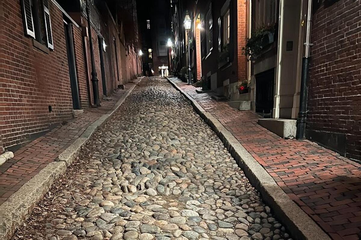una calle adoquinada por la noche en un callejón