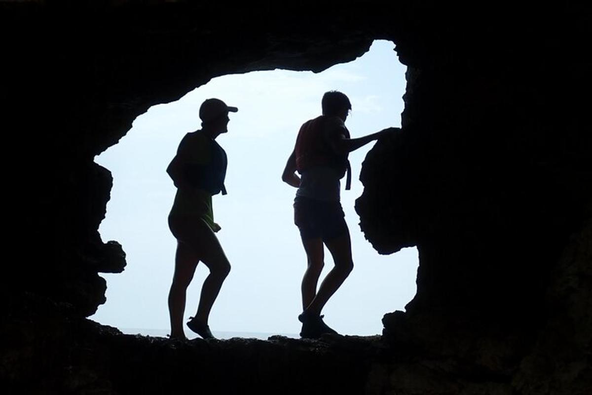 three men standing inside of a cave