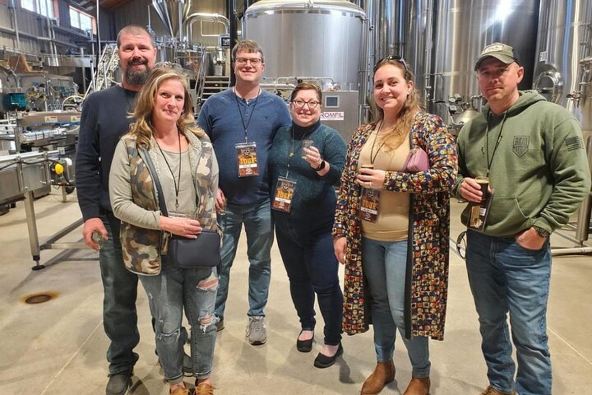 a group of people posing for a picture in a brewery