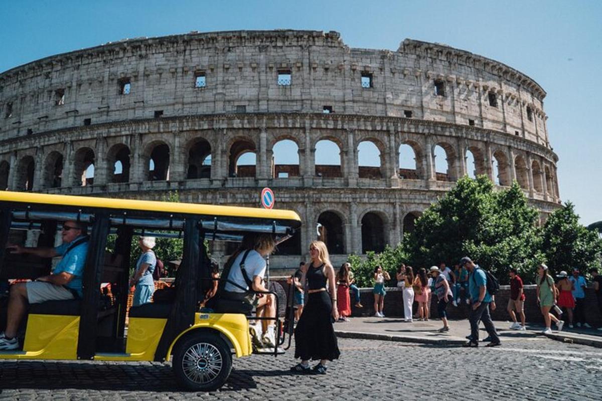 a yellow golf cart in front of the coliseum