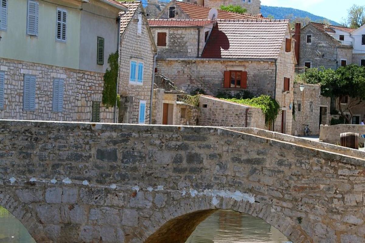 an old stone bridge over a river in a city