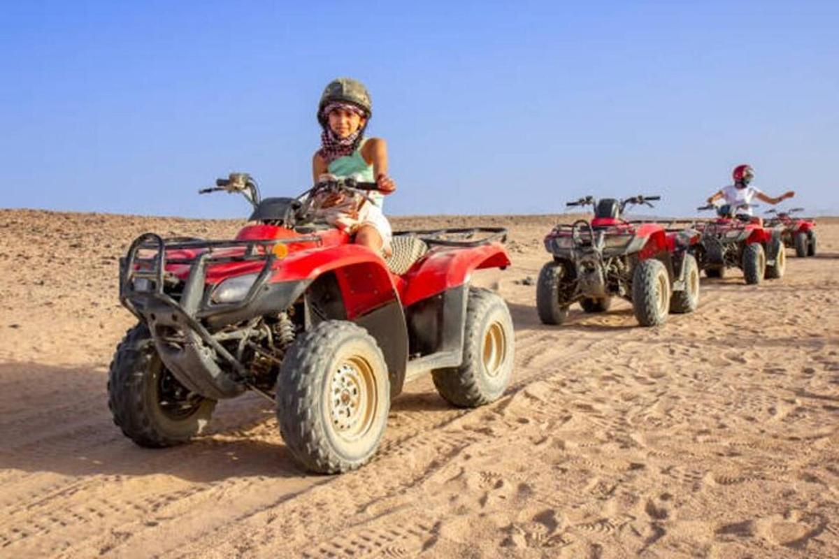 sekumpulan orang menunggang atv di pantai