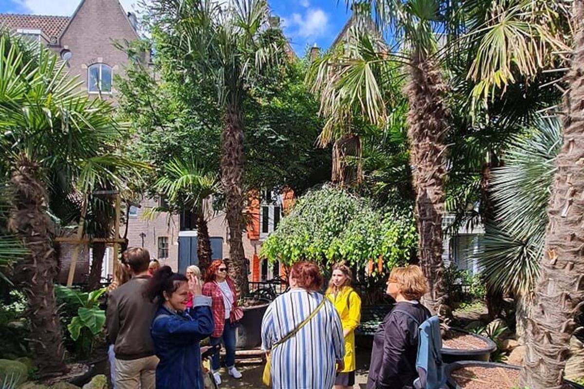 Μια ομάδα ανθρώπων που στέκονται σε έναν κήπο με φοίνικες