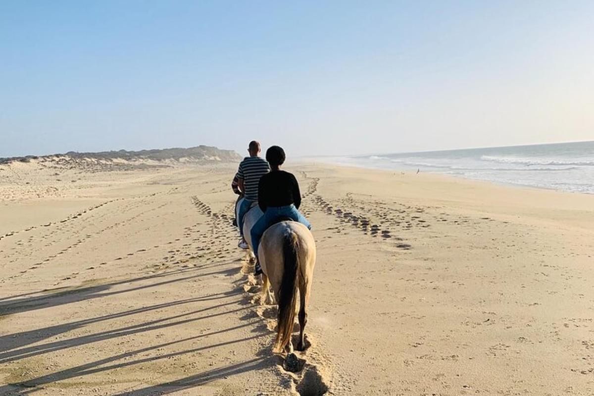 en gruppe mennesker som rir på hester på stranden