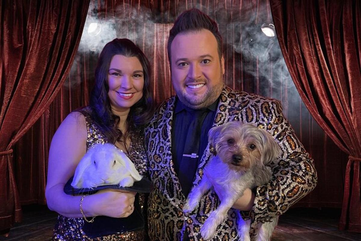 a man and a woman holding a dog and a puppy