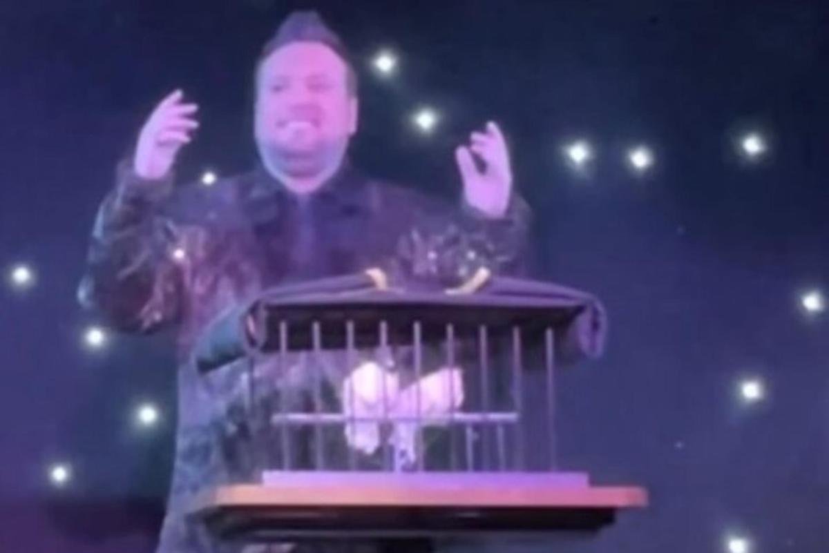 a man standing in front of a bird cage