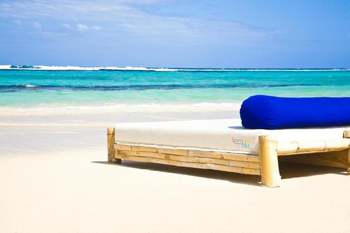 a bed on a beach with the ocean in the background