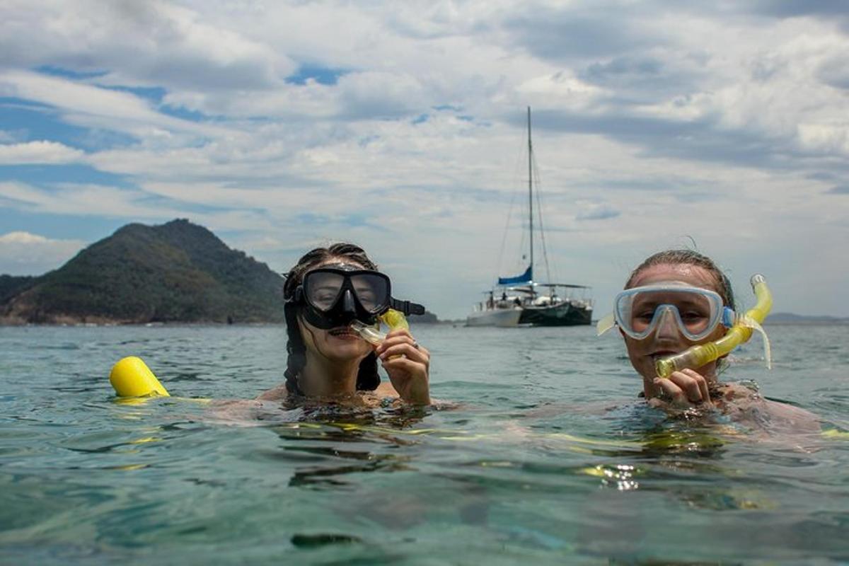 a man and woman in the water eating bananas