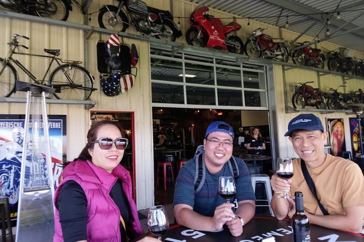 isang grupo ng tatlong tao na nakaupo sa isang mesa na may mga baso ng alak