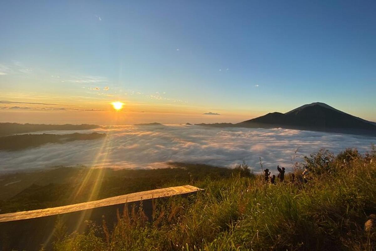 pemandangan gunung dengan matahari terbit di atas awan
