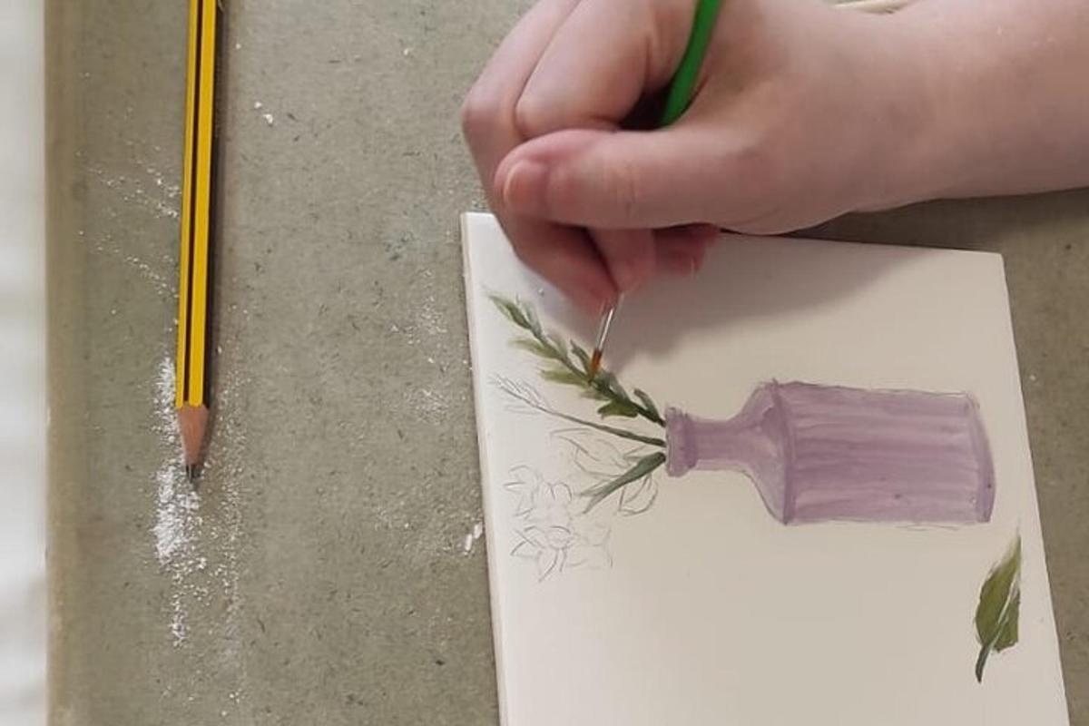 una persona cortando un trozo de papel con un lápiz