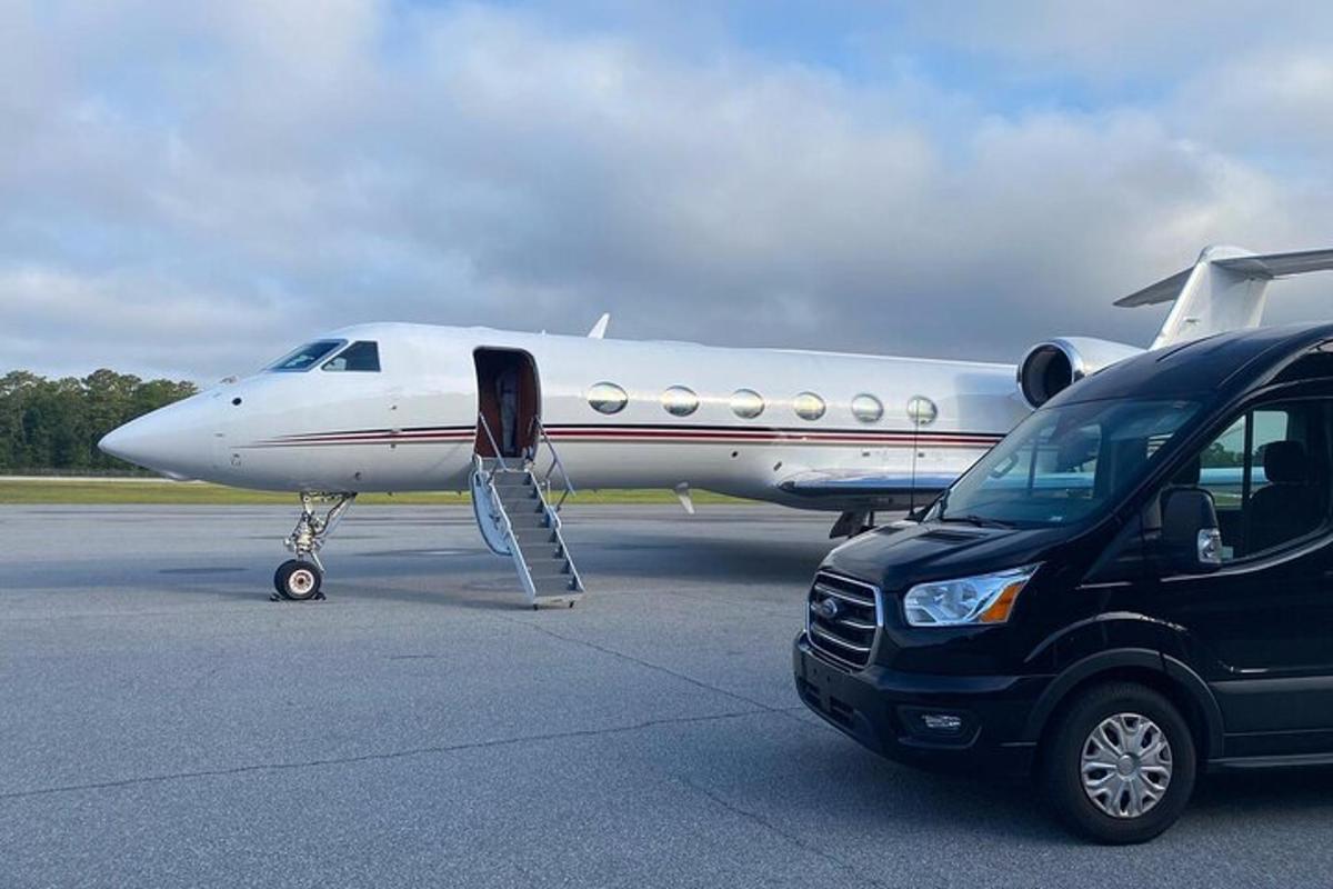un'auto parcheggiata accanto a un aereo su una pista
