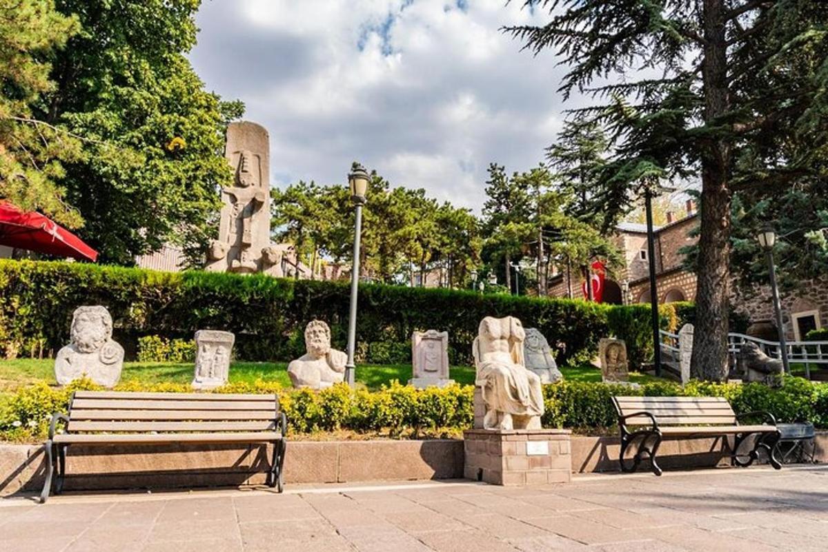 sebuah taman dengan dua bangku dan patung di dalamnya