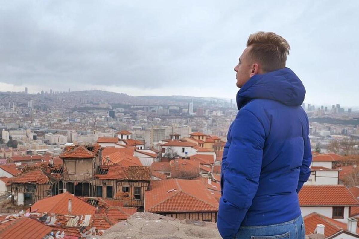 a man in a blue jacket looking at a city