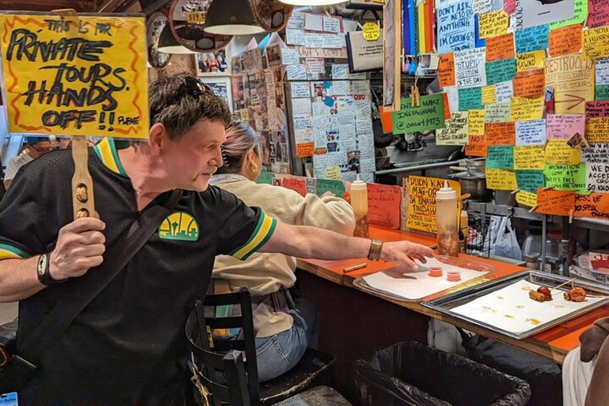 a man holding a sign in front of a counter