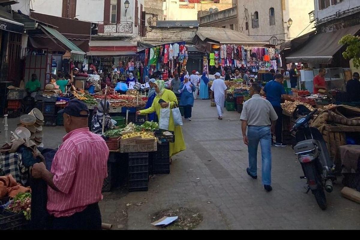 a group of people walking through an outdoor market