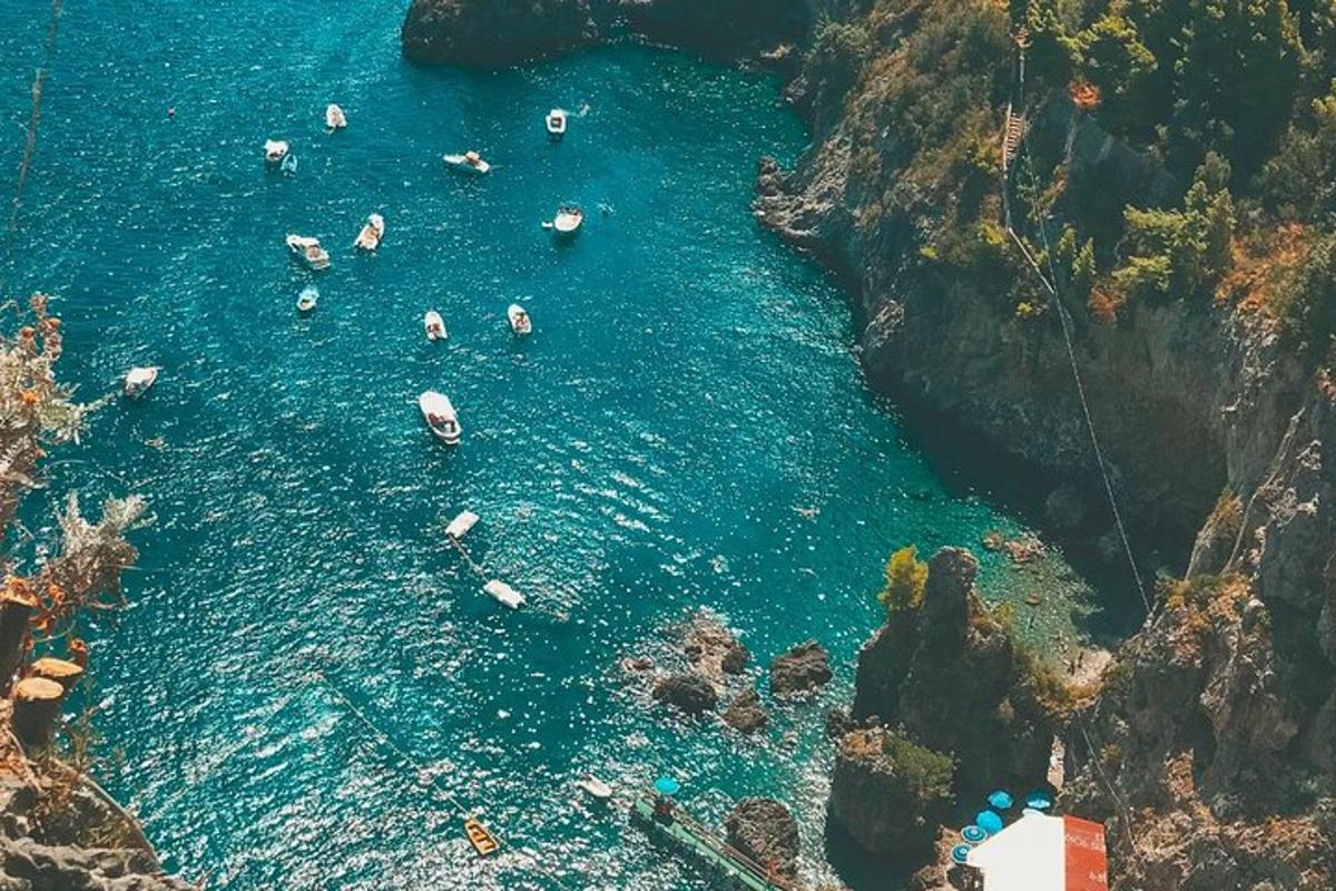 eine Gruppe von Menschen im Wasser in der Nähe einer Klippe