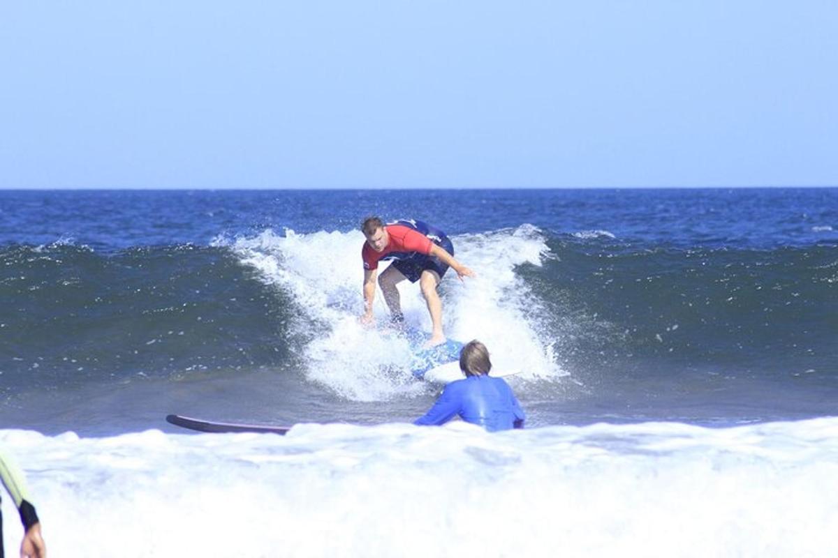 un home cavalcant una onada sobre una taula de surf a l'oceà