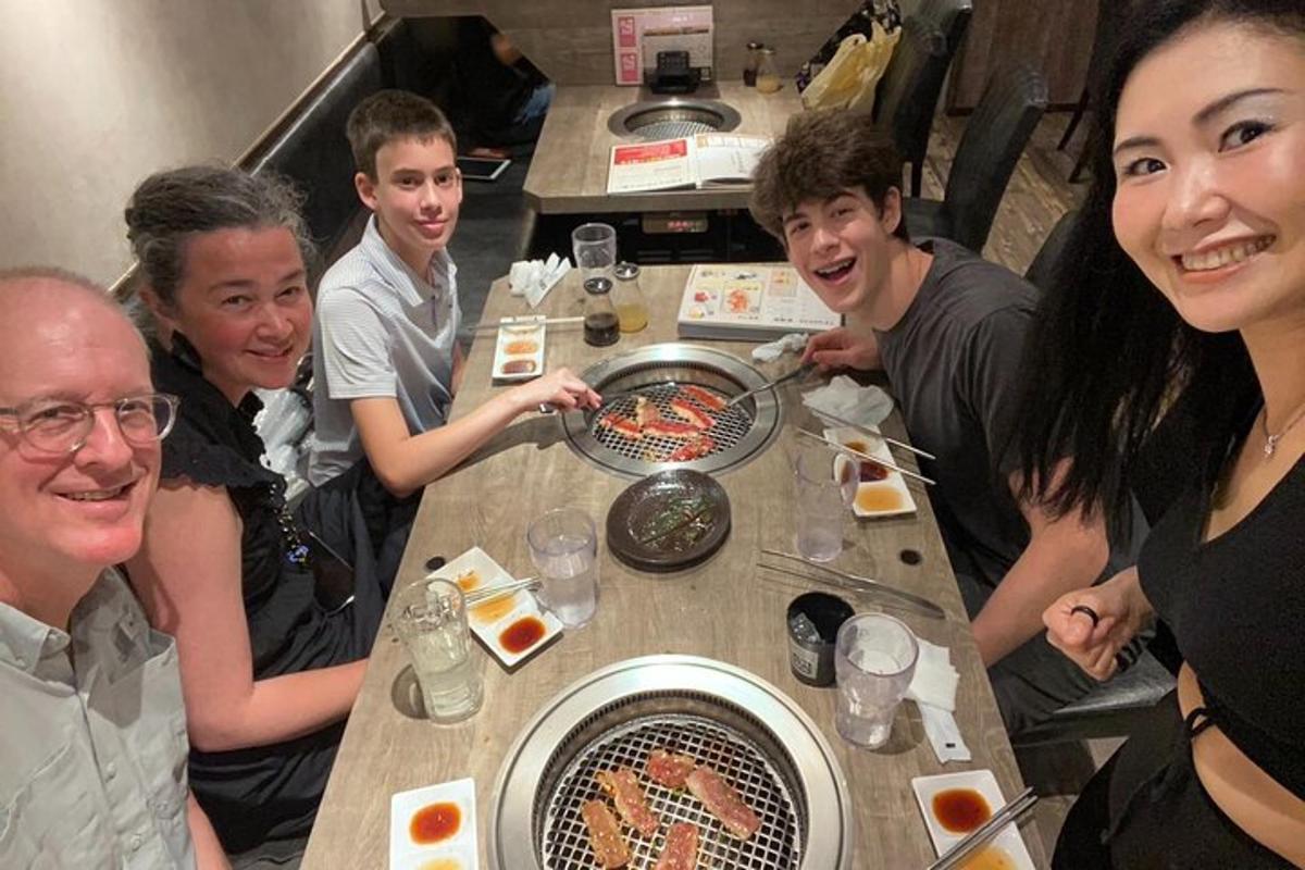 um grupo de pessoas sentadas ao redor de uma mesa comendo comida