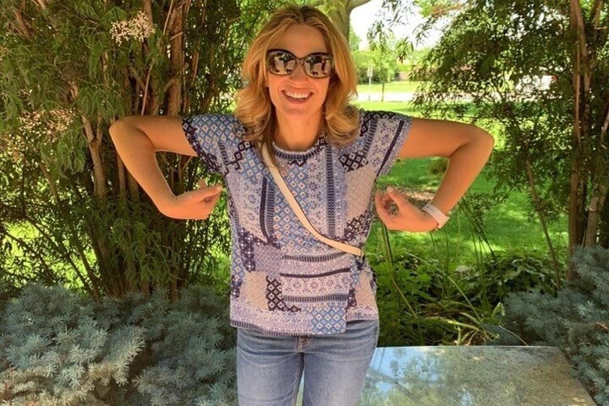 güneş gözlüğü takan ve kollarını kavuşturmuş bir kadın
