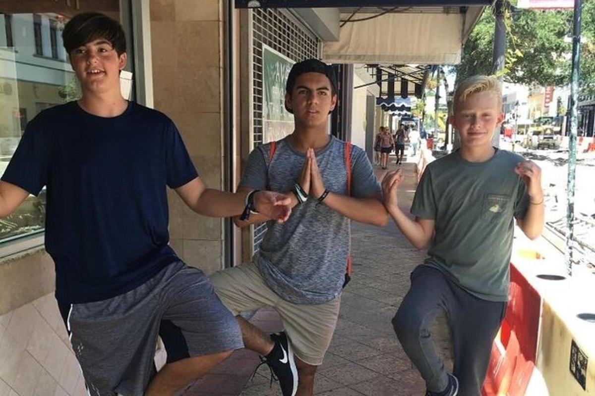 Tres jóvenes aplauden frente a una tienda