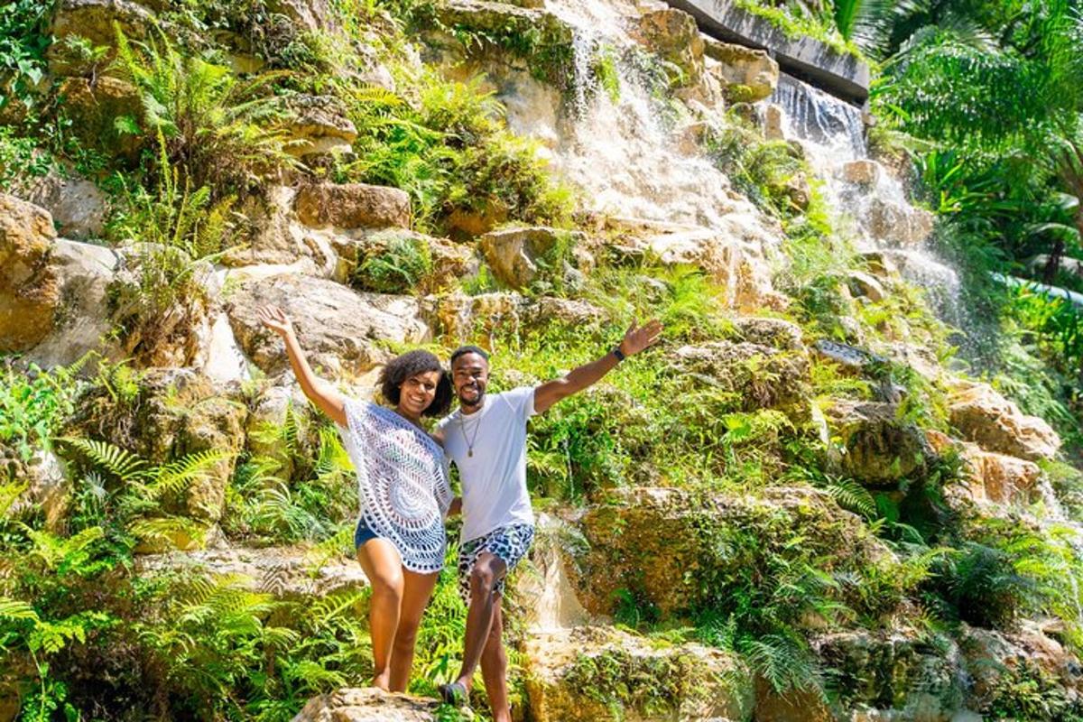 a man and a woman standing in front of a waterfall
