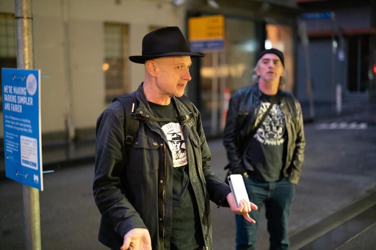 two men in hats walking down a street