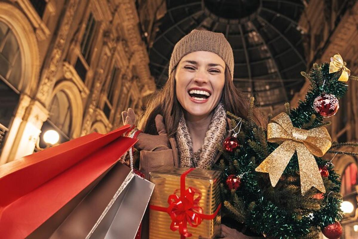 a woman is holding a pile of christmas presents