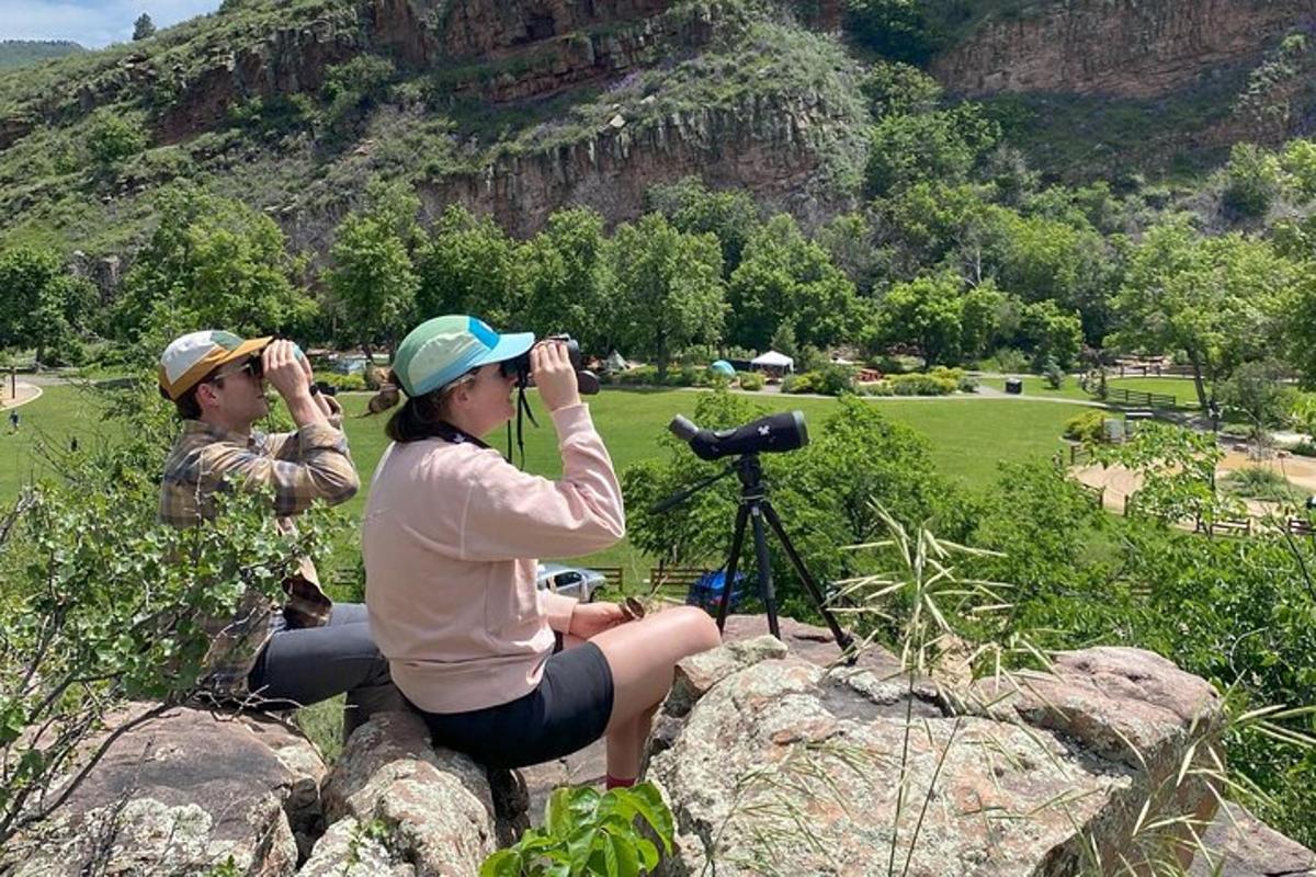 dua orang duduk di atas batu mengambil gambar padang golf
