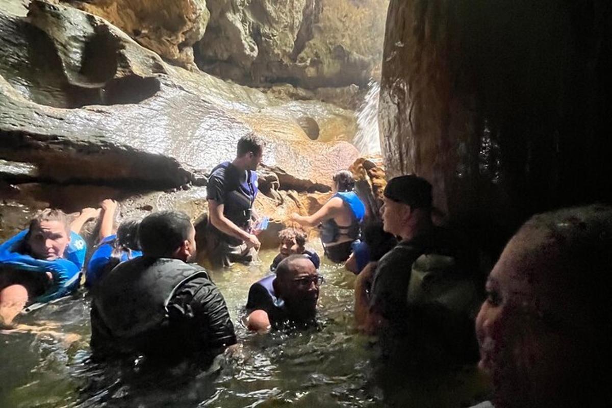 a group of people in the water in a cave