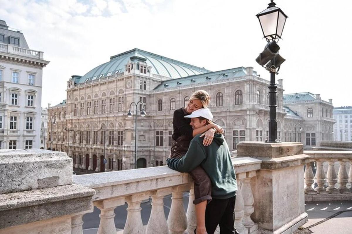 a woman hugging a man on a bridge in front of a building
