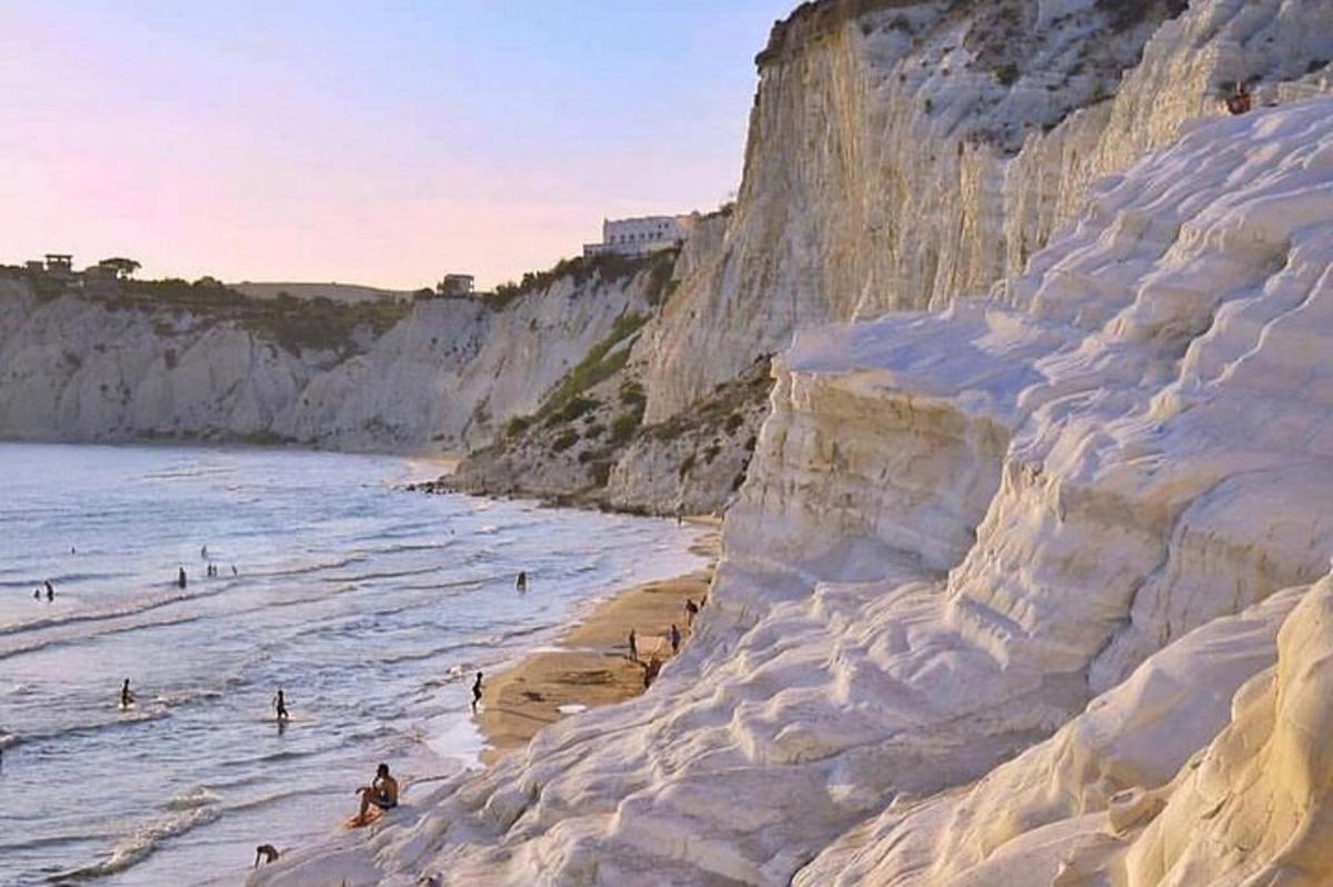 lukisan orang di pantai bersebelahan lautan